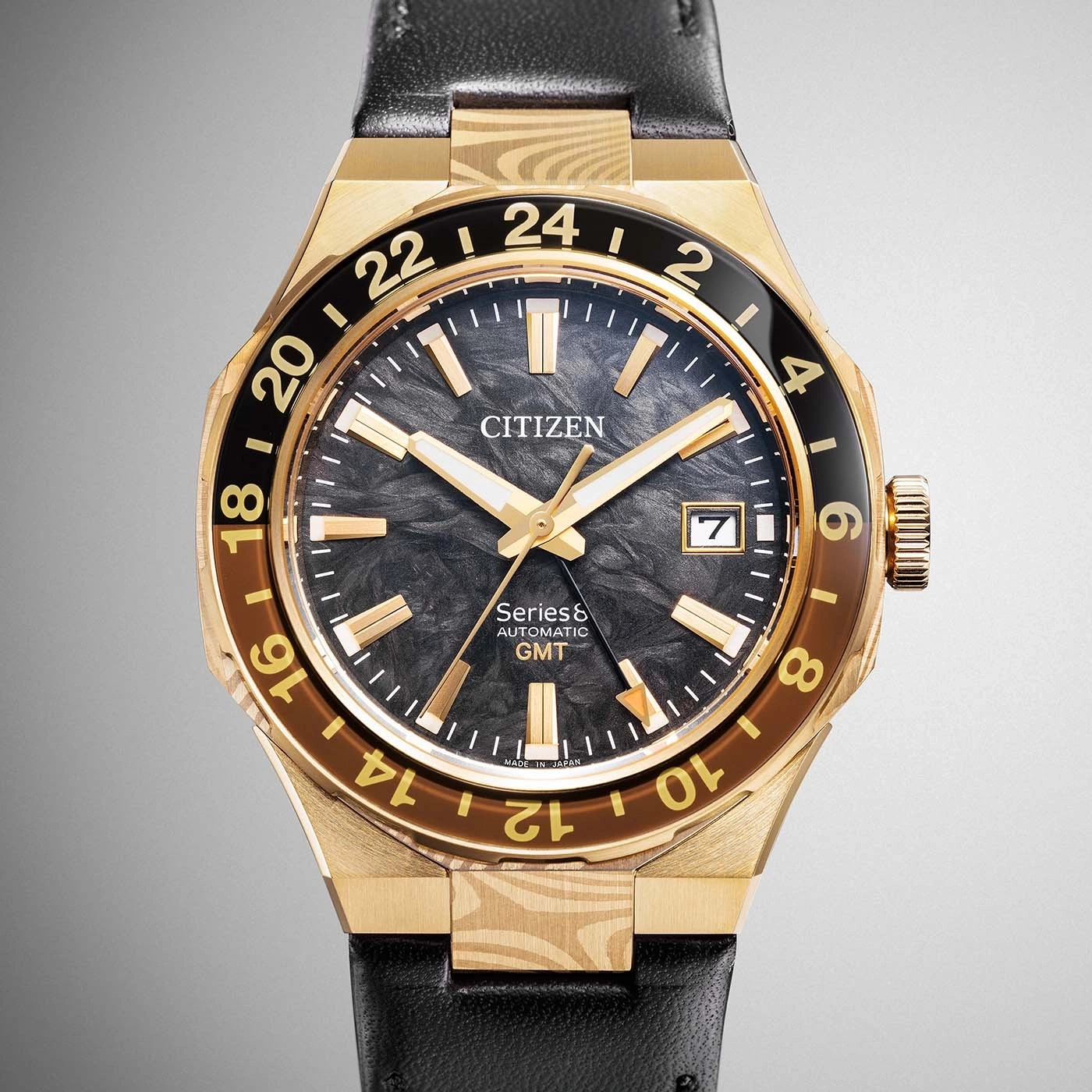 Eine goldene Citizen Series8 Automatikuhr mit GMT-Funktion, schwarzem Zifferblatt und schwarzem Lederarmband.