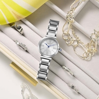 Eine silberne Citizen Eco-Drive Uhr mit Ringen und Armbändern in einer Schmuckschatulle.
