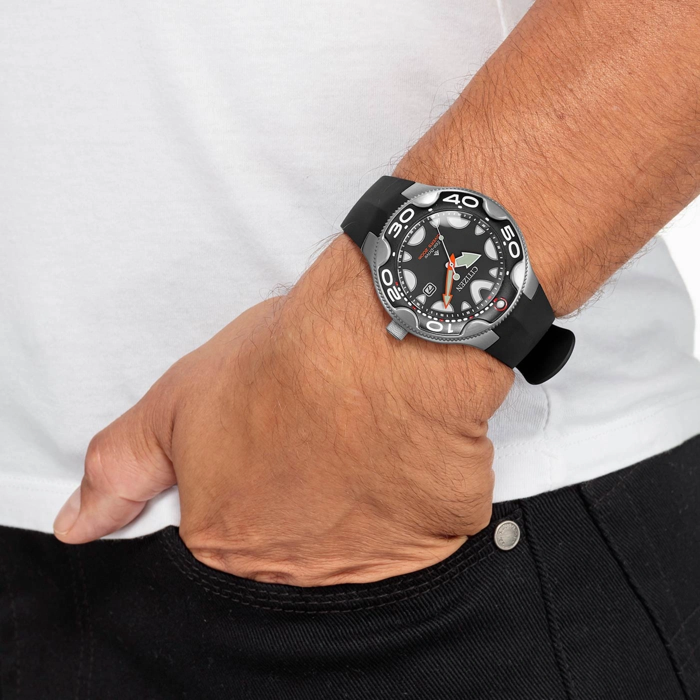 Mann mit Citizen-Uhr, schwarzem Armband, in der Tasche, schwarze Jeans, weißes Hemd.