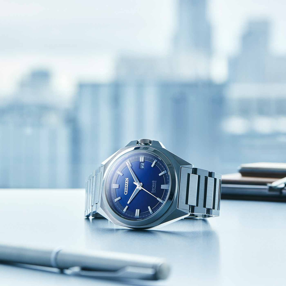 Citizen Series 8 Uhr mit blauem Zifferblatt auf einem Schreibtisch mit Stift.